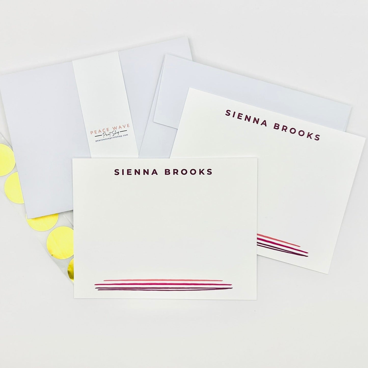 Set of personalized stationery items with name 'Sienna Brooks' on a white background plus envelopes and gold sticker seals