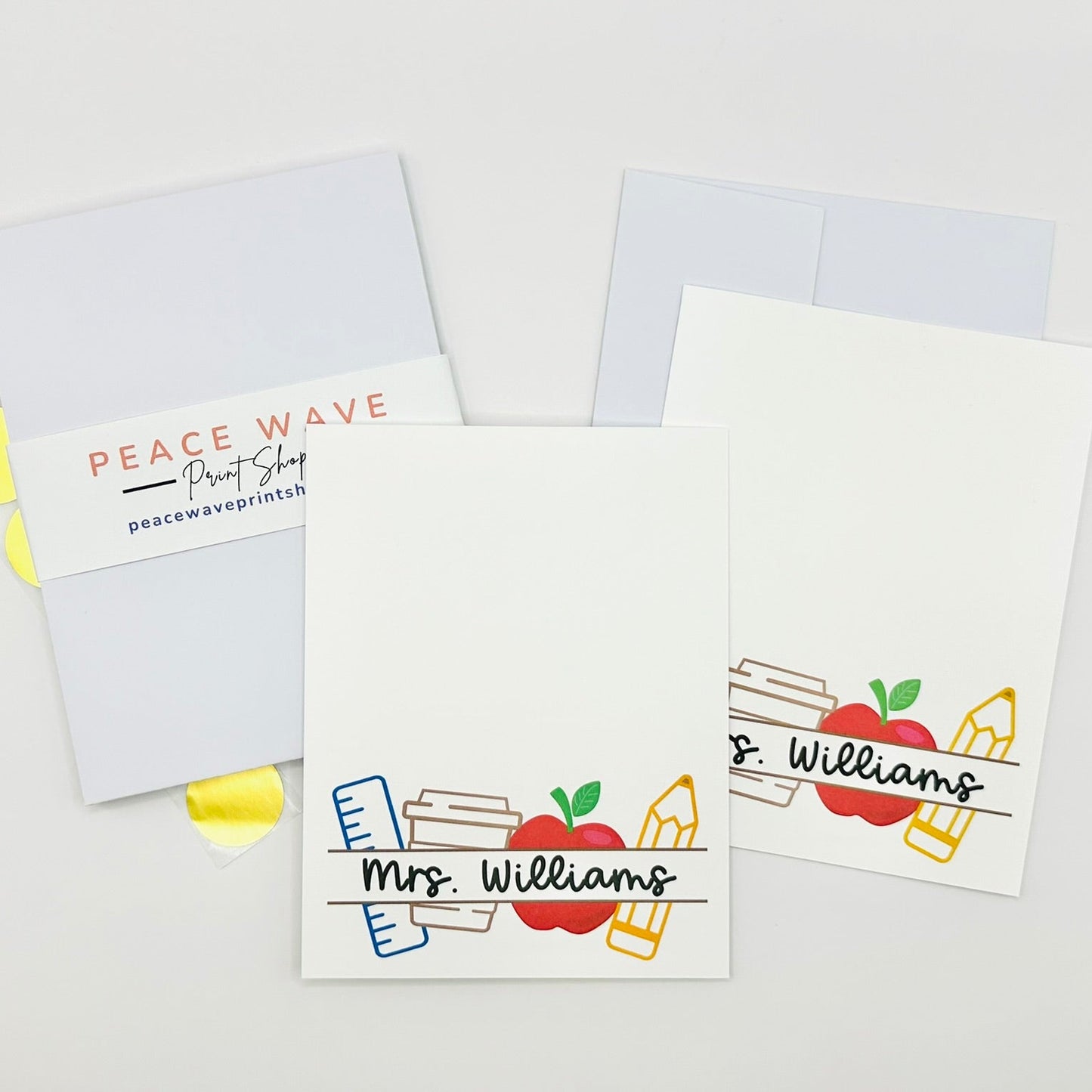 Personalized flat stationery cards with teacher's name and design elements on a white background plus envelopes and gold sticker seals
