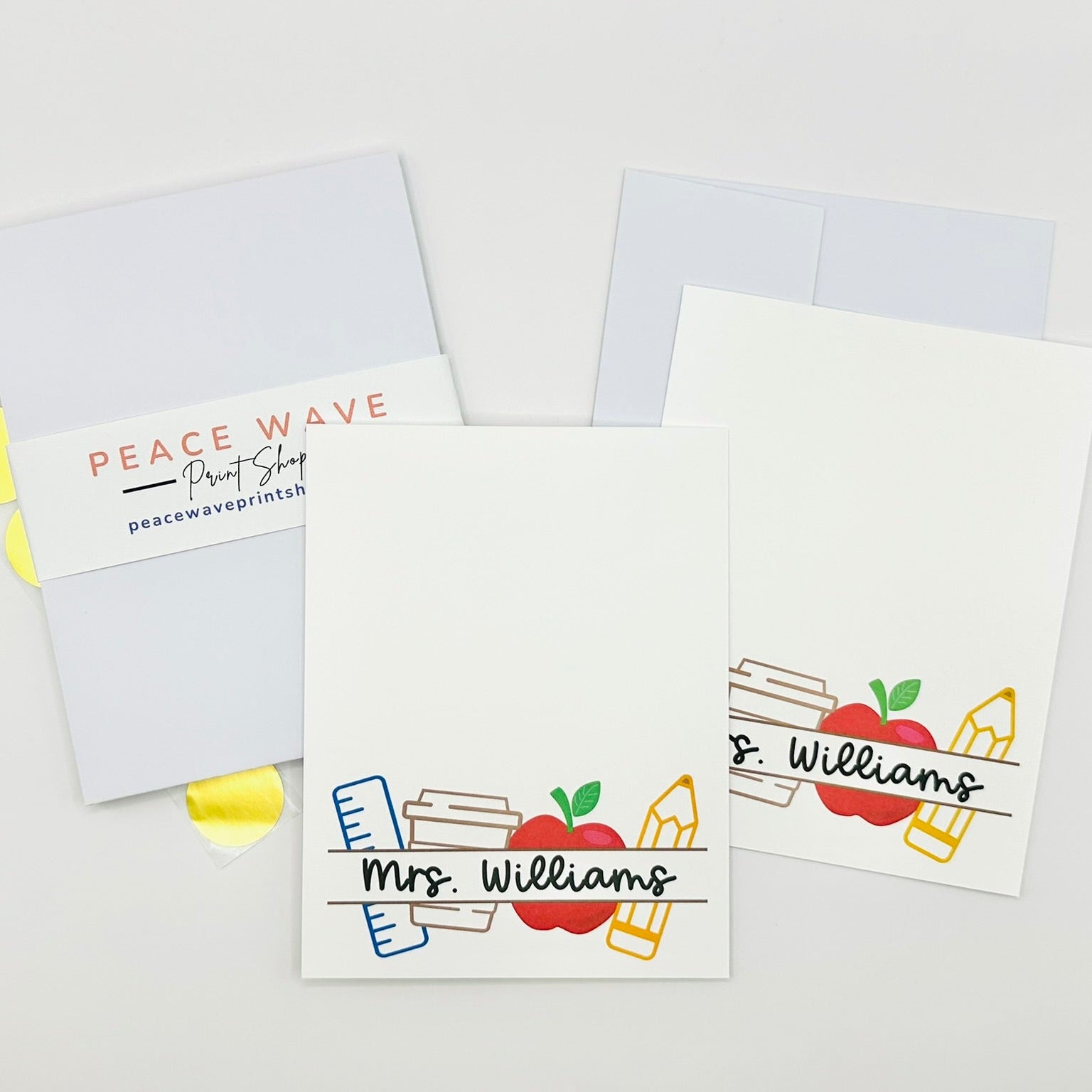 Personalized flat stationery cards with teacher's name and design elements on a white background plus envelopes and gold sticker seals