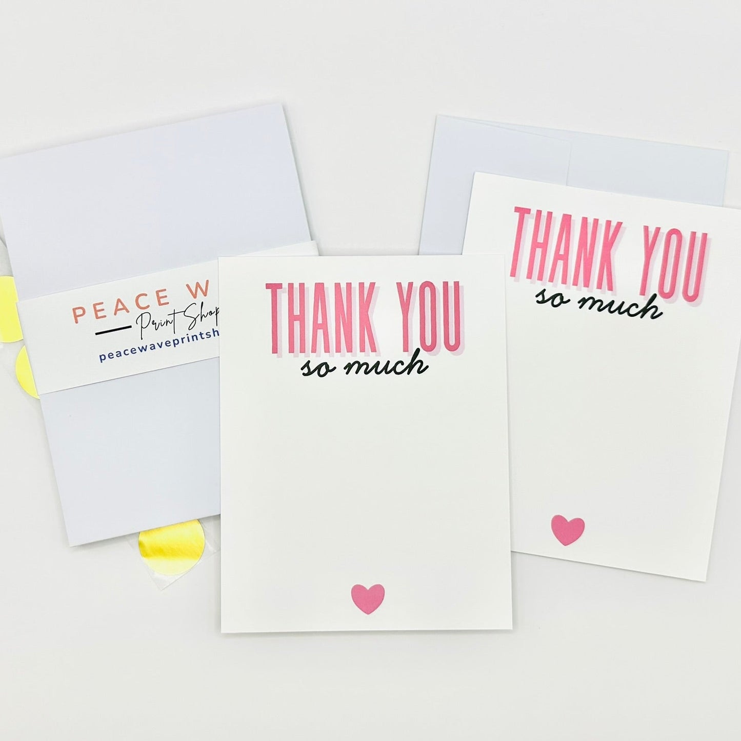 Stationery set flat 'Thank You' cards with pink hearts and coordinating envelopes and gold sticker seals on a white background