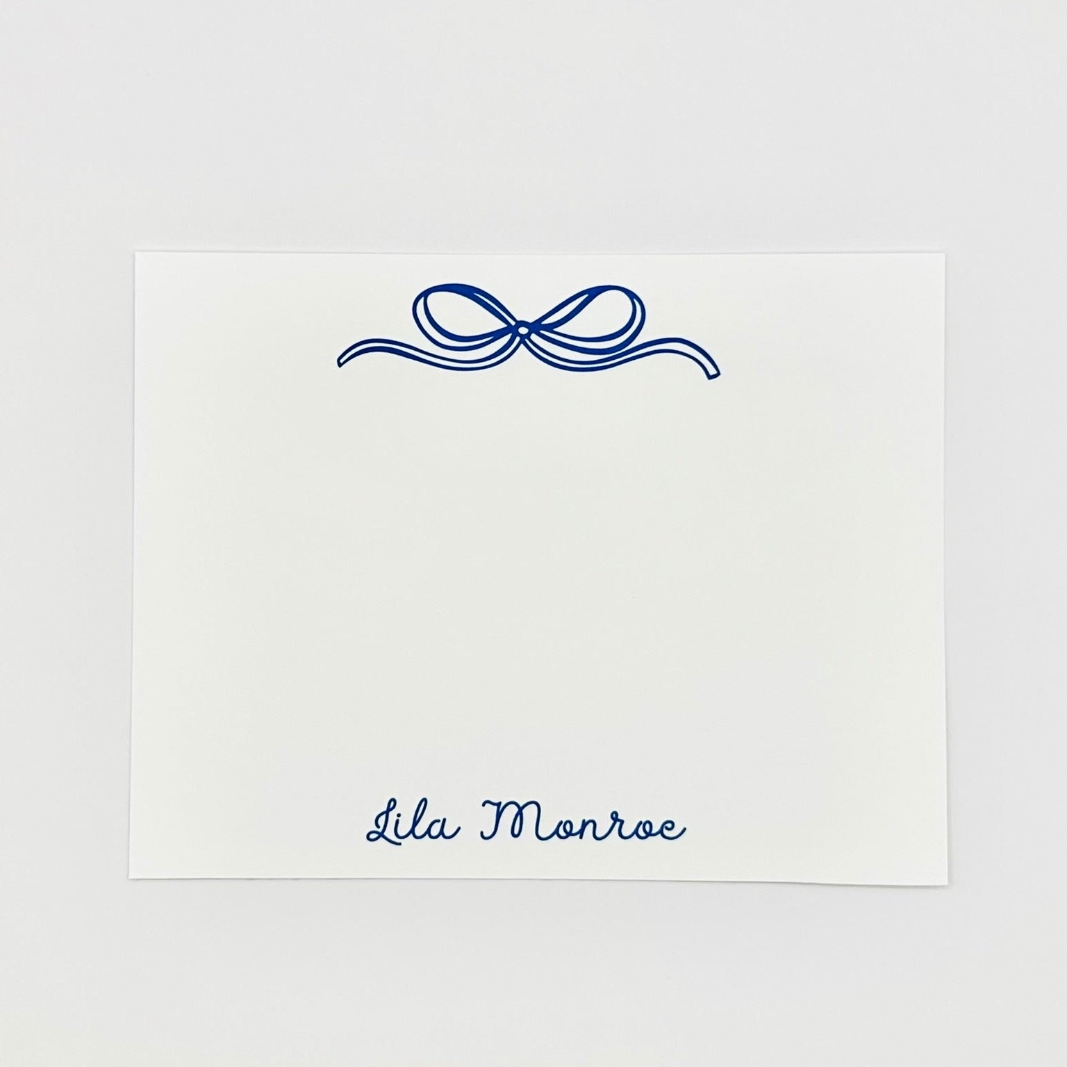 Personalized note card with decorative blue bow and name 'Lila Monroe' on a white background