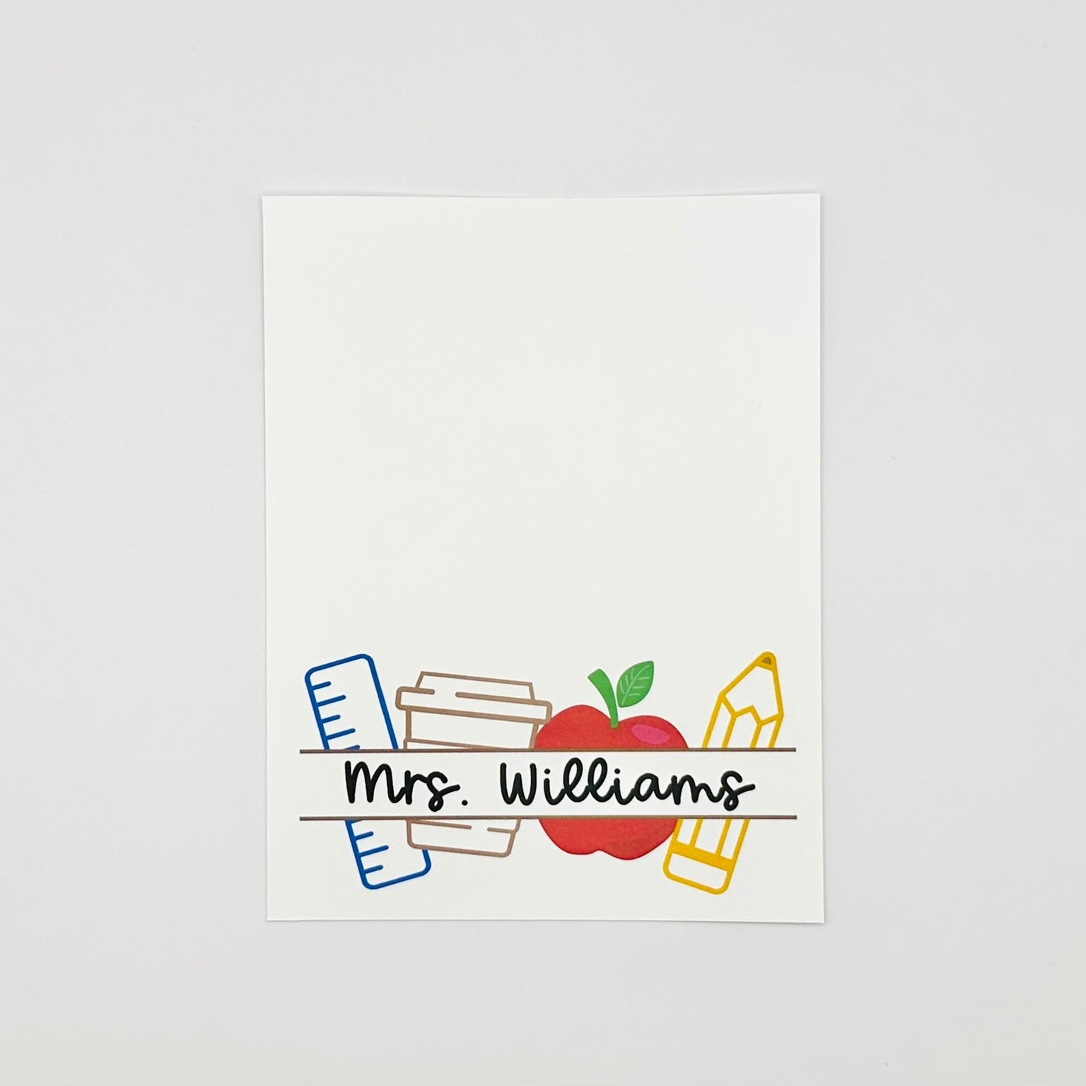 Personalized teacher name card with an apple and pencils on a white background