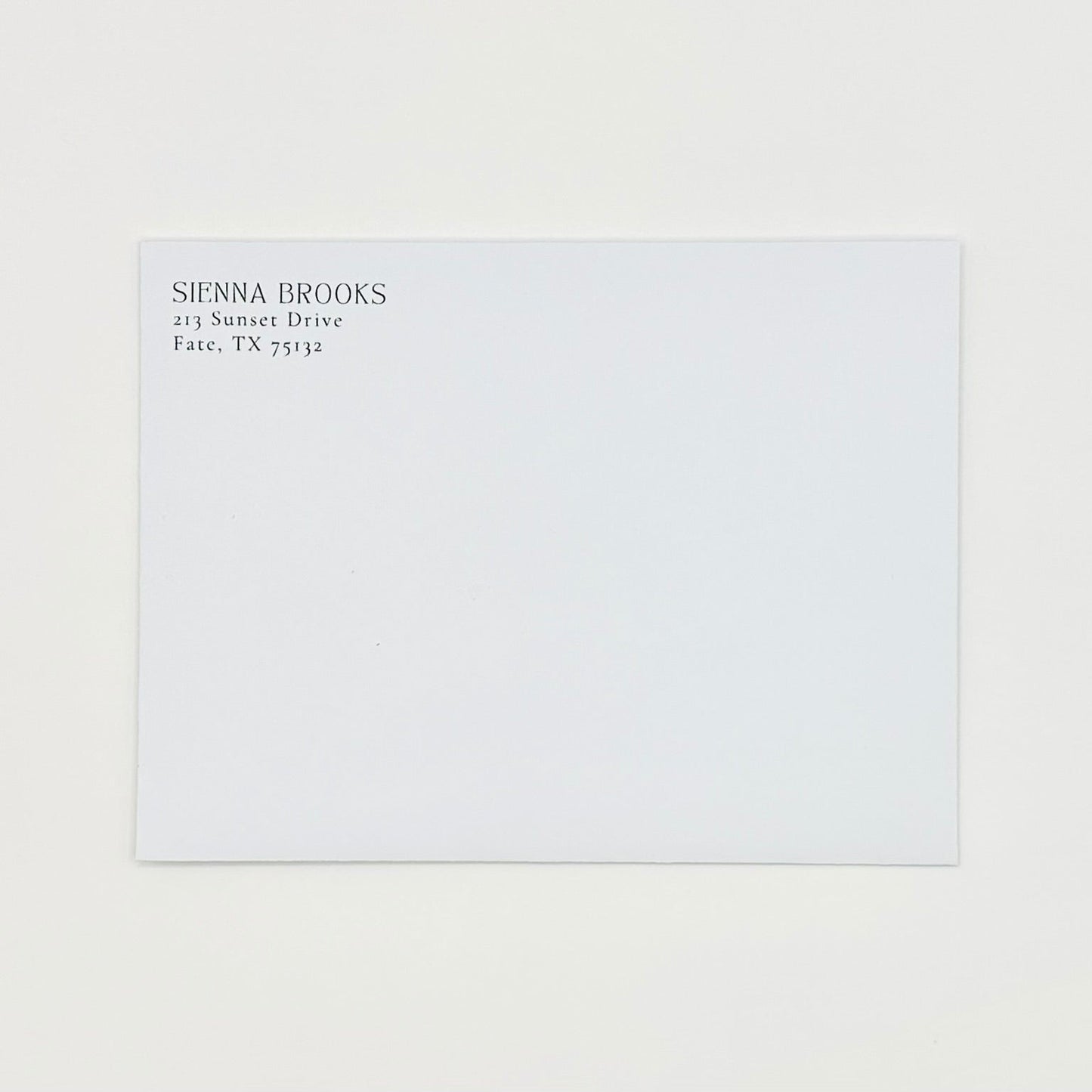 White envelope with black text return address on a white background