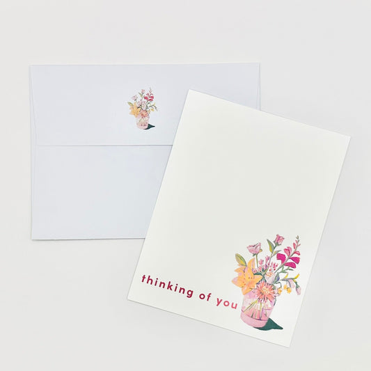 Flat stationery greeting card with floral design and 'thinking of you' text on a white background and coordinating envelope