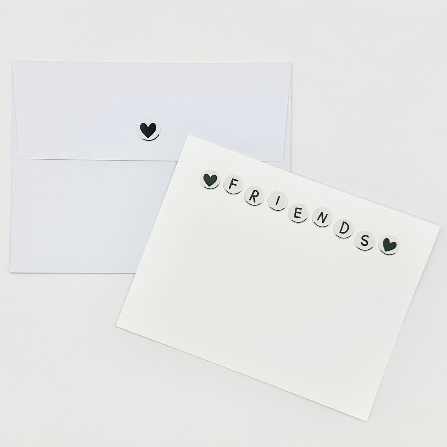 Stationery white card with 'FRIENDS' text and heart symbols on a white background
