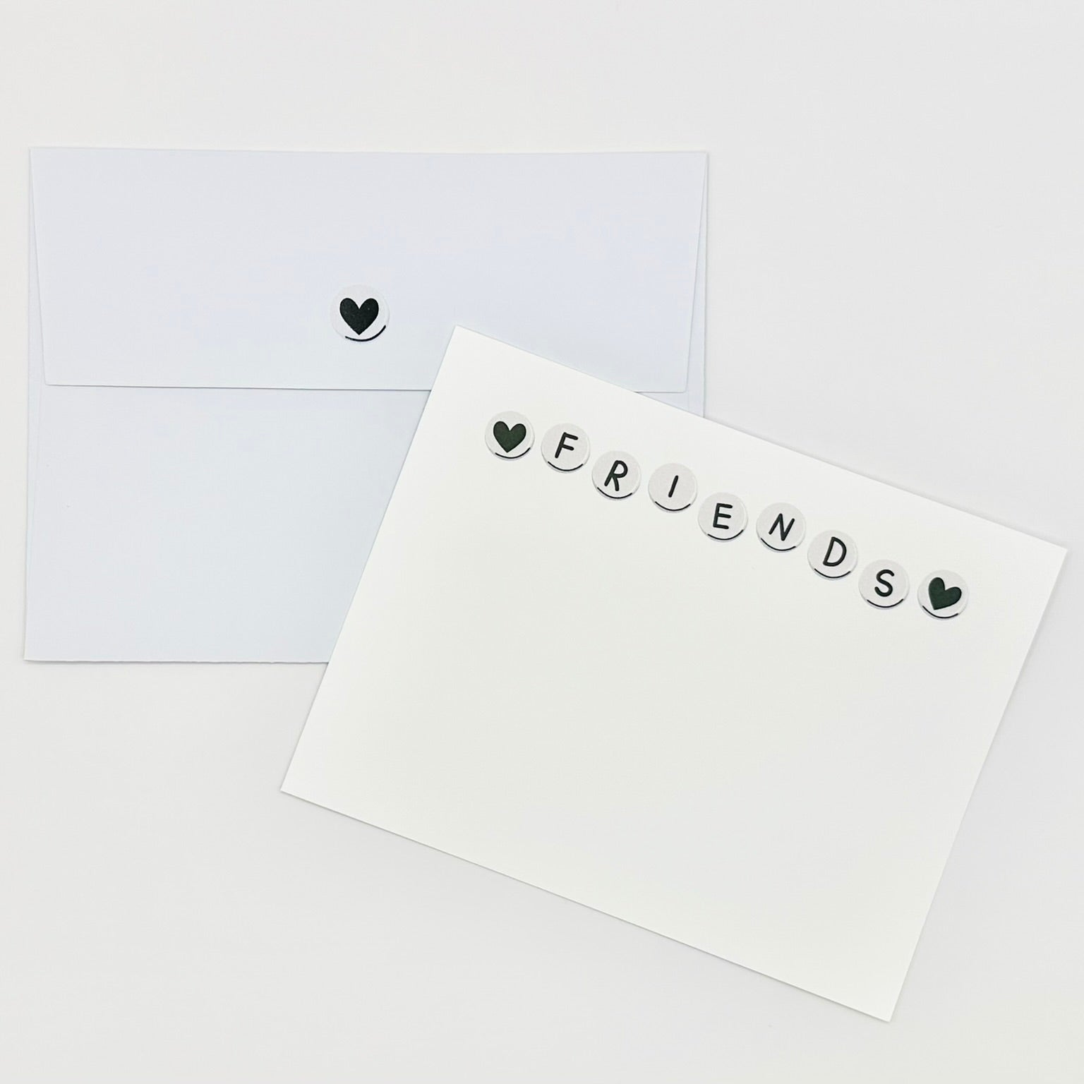 Stationery white card with 'FRIENDS' text and heart symbols on a white background