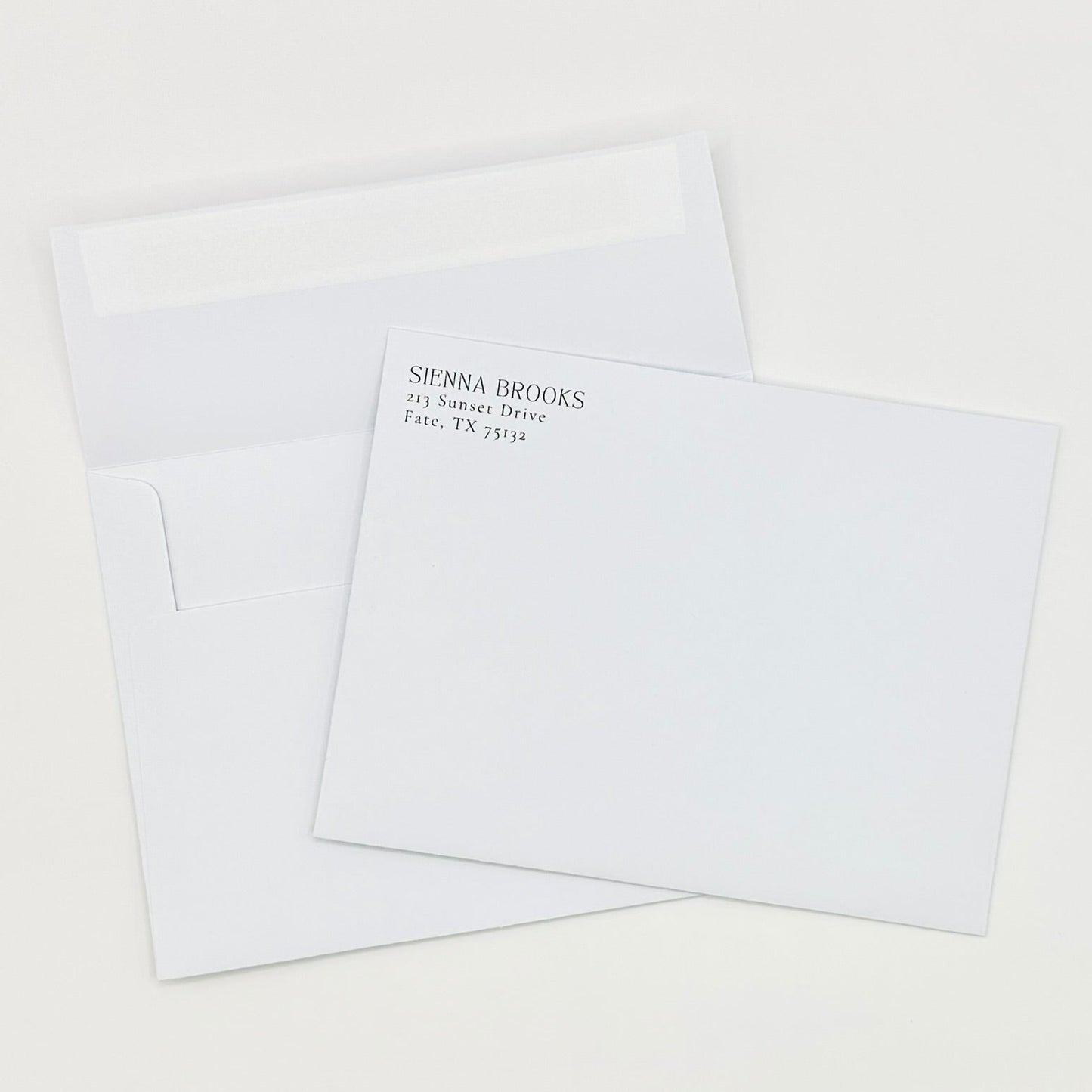 White envelopes with personalized return address and self-seal sticker edge on a white background
