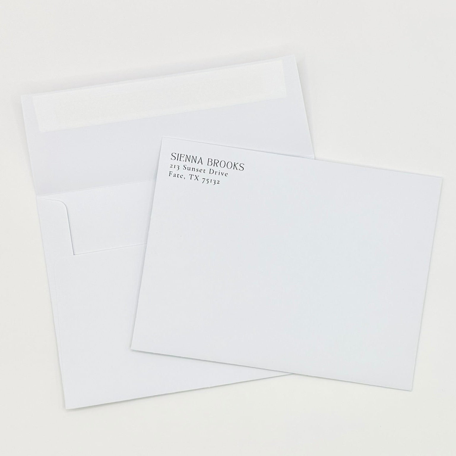 White envelopes with personalized return address and self-seal sticker edge on a white background